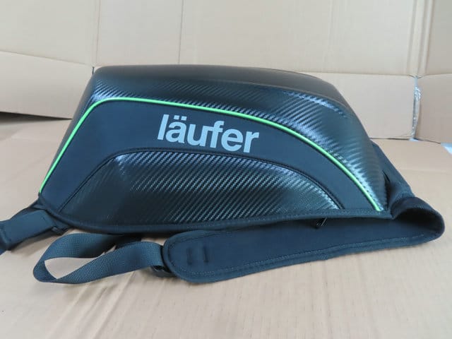 Bolso rígido deportivo Läufer en color negro con detalles verdes, visto de perfil.