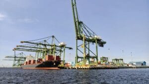 Buque cargado con contenedores en puerto con grúas, gestión de importación profesional