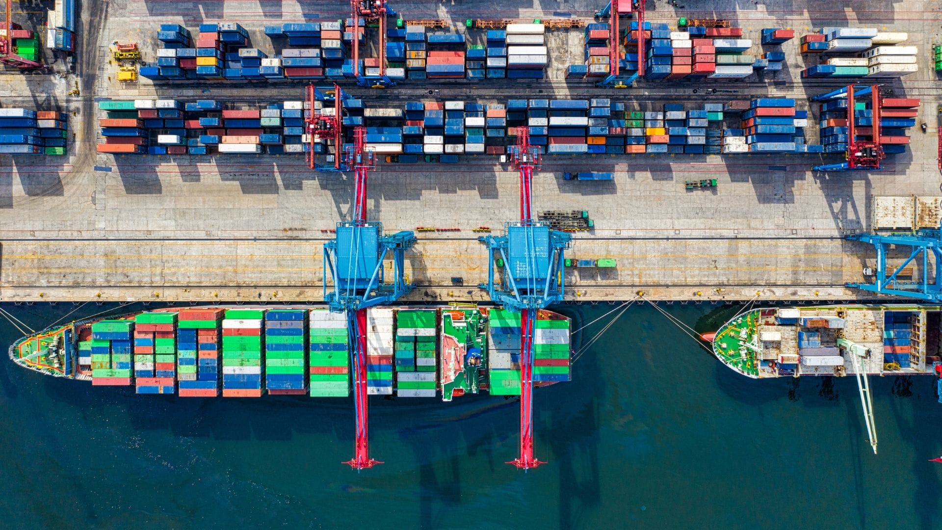 Vista aérea de puerto con contenedores y grúas para importación de empresas