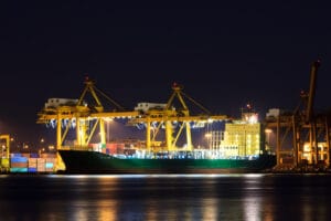 Buque de carga operando en terminal portuaria durante operaciones logísticas de importación internacional